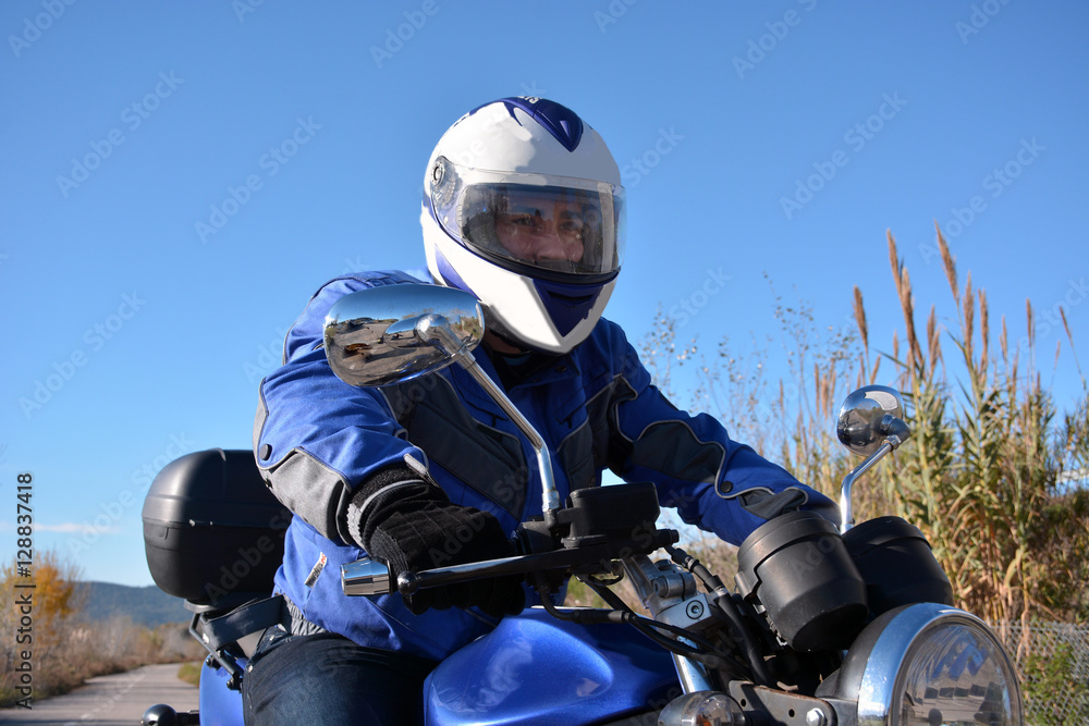 biker with helmet blue going by a road biker with helmet blue going by a road