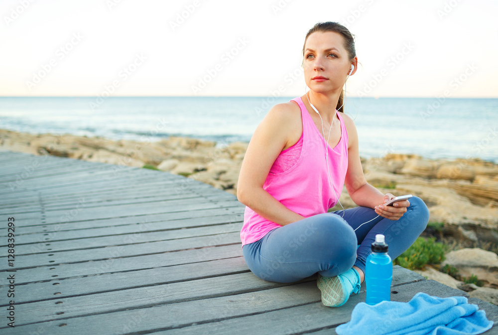 Athletic woman resting after running at the morning training by