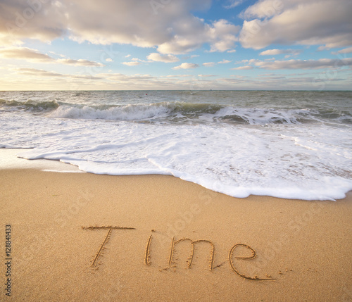 Time word on the sea sand.