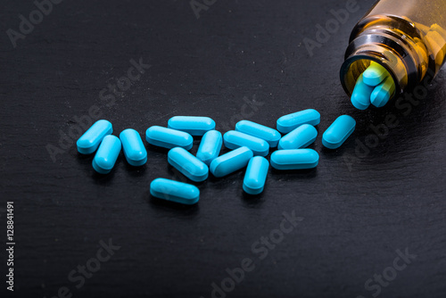 Blue pills in a bottle, medicines painkiller. Medications drugs, tablets.