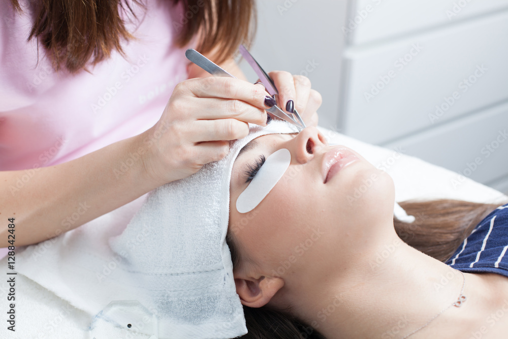 Naklejka premium beautician making artificial lashes. eyelash extension procedure 