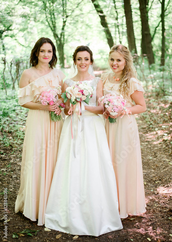 happy and young bride and her bridesmaids standing together © IVASHstudio
