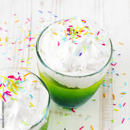 Colorful jelly with whipped cream and candy topping