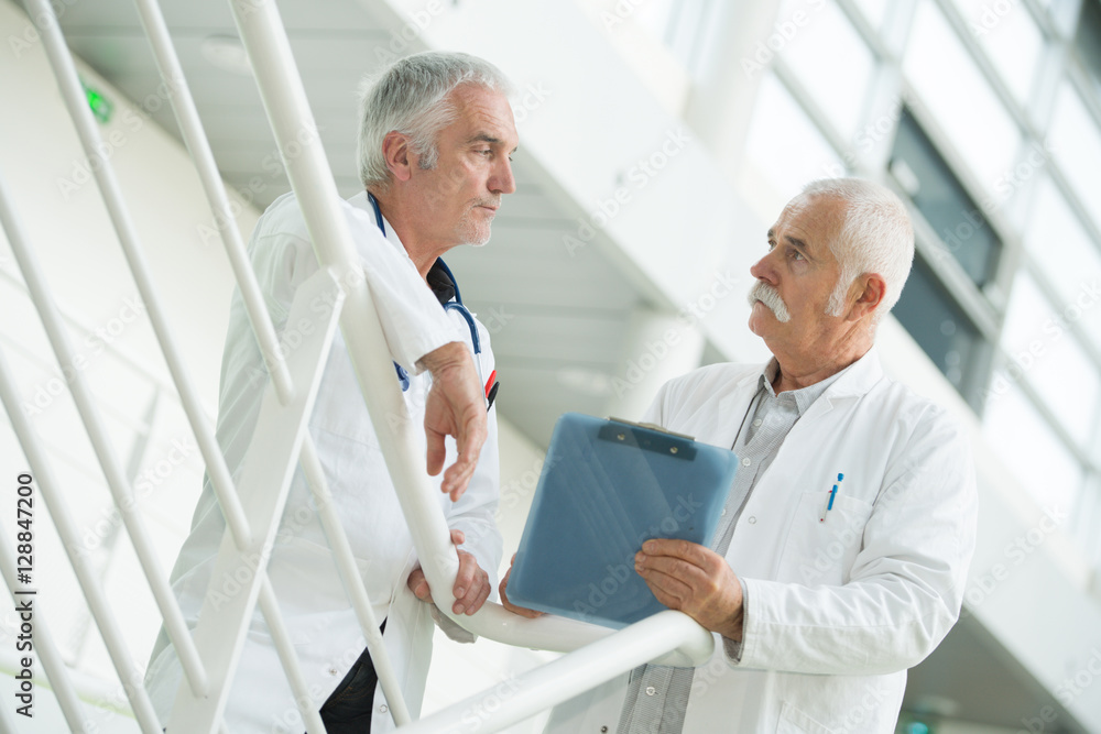 Fototapeta premium Senior workers in discussion on staircase