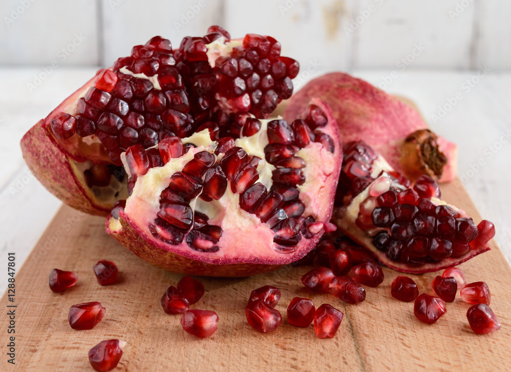 Ripe garnet have broken into pieces on a white background. Juicy Asian fruit. Close up. Ripe garnet have broken into pieces on a white background. Juicy Asian fruit. Close up.