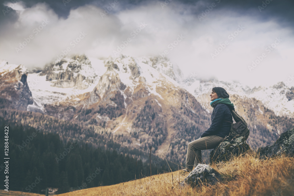 young woman traveler sitting with a view of the Dolomites Alps i