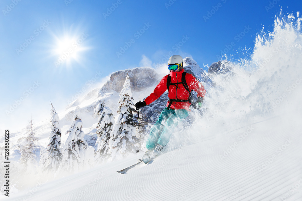 Freeride skier on piste running downhill