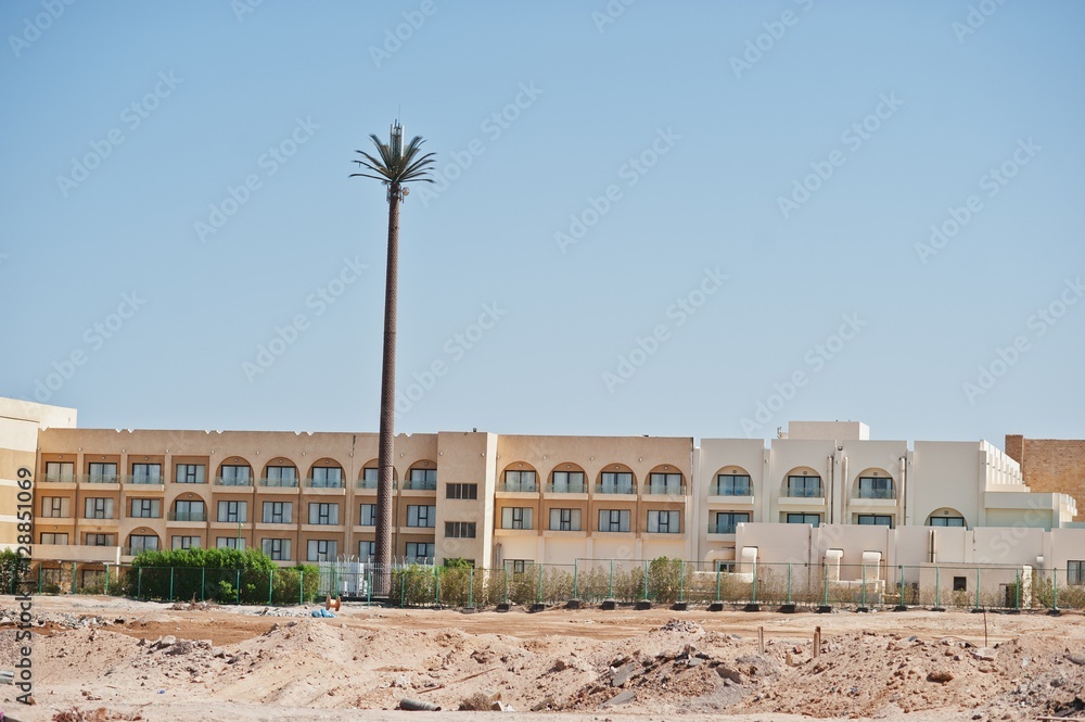 Building on sand with large radio station like palm