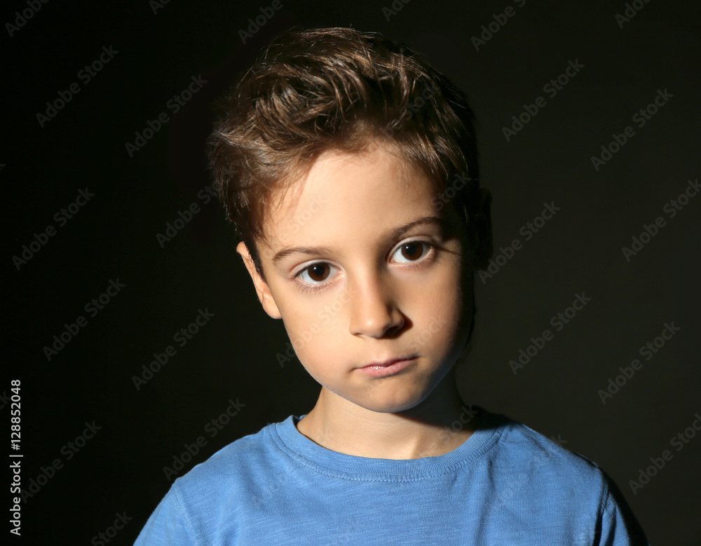 Cute little boy on black background