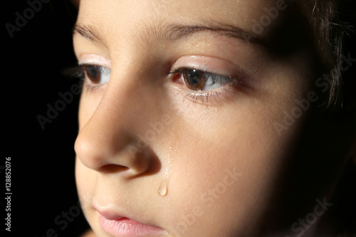 Little crying boy on black ...