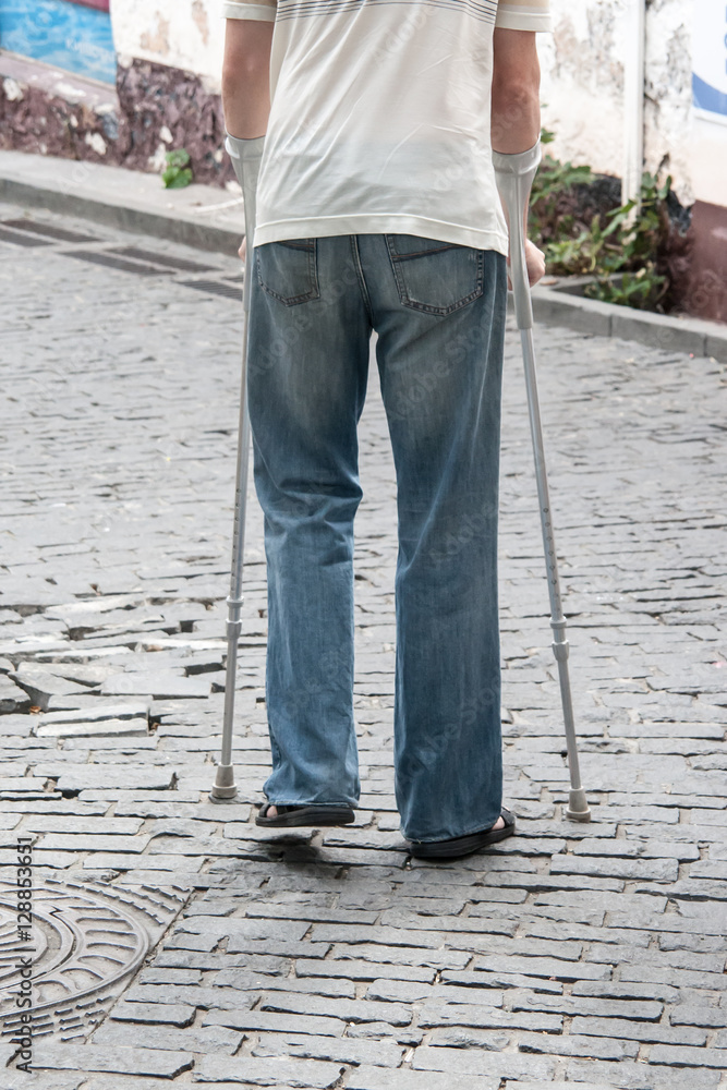the disabled person walks in park on crutches