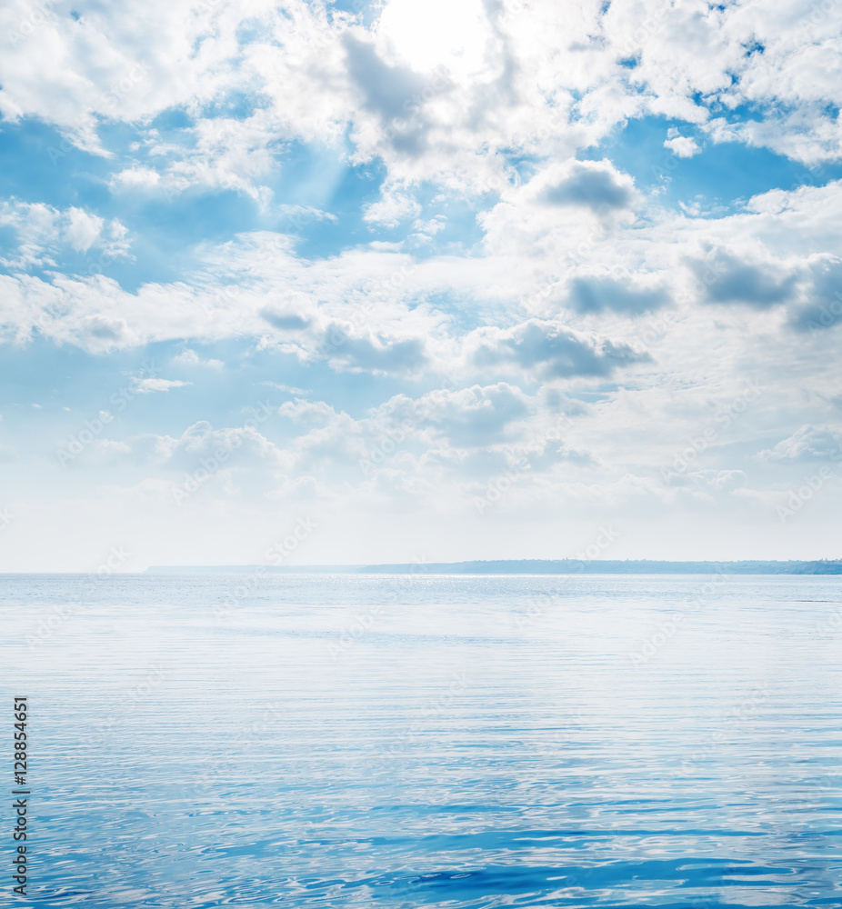 Obraz premium big river with little waves and clouds in blue sky