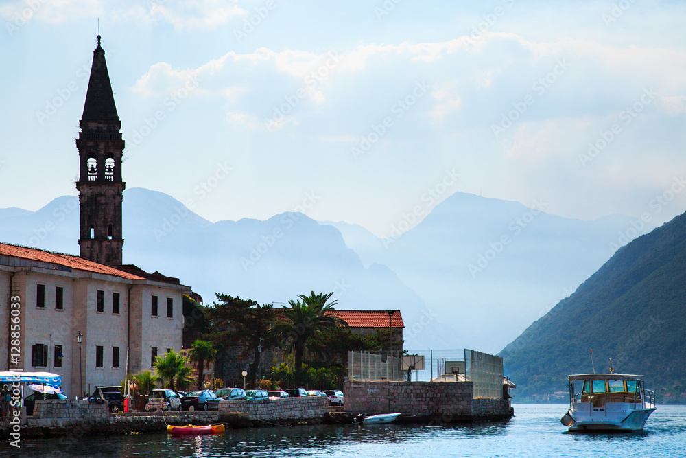 Cityscape and boat on background of mountains. View of Perast old town in Bay of Kotor, Montenegro.
