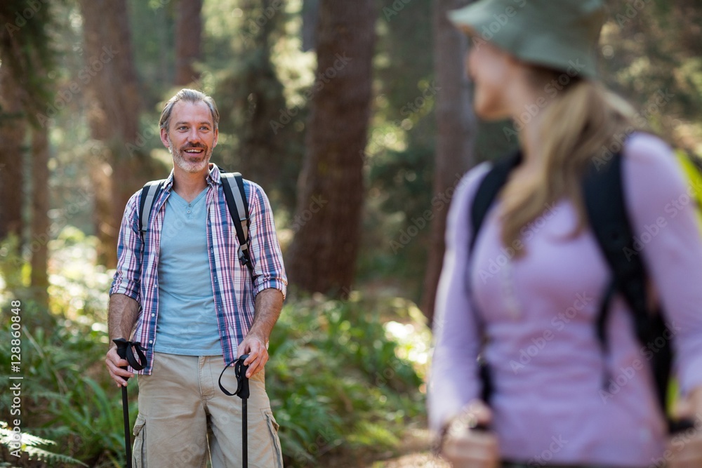 Smiling hiker hiking with trekking poles Smiling hiker hiking with trekking poles