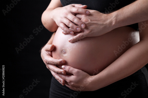 Portrait of parents holding a pregnant belly