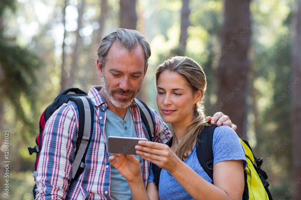 Hiker couple using mobile phone