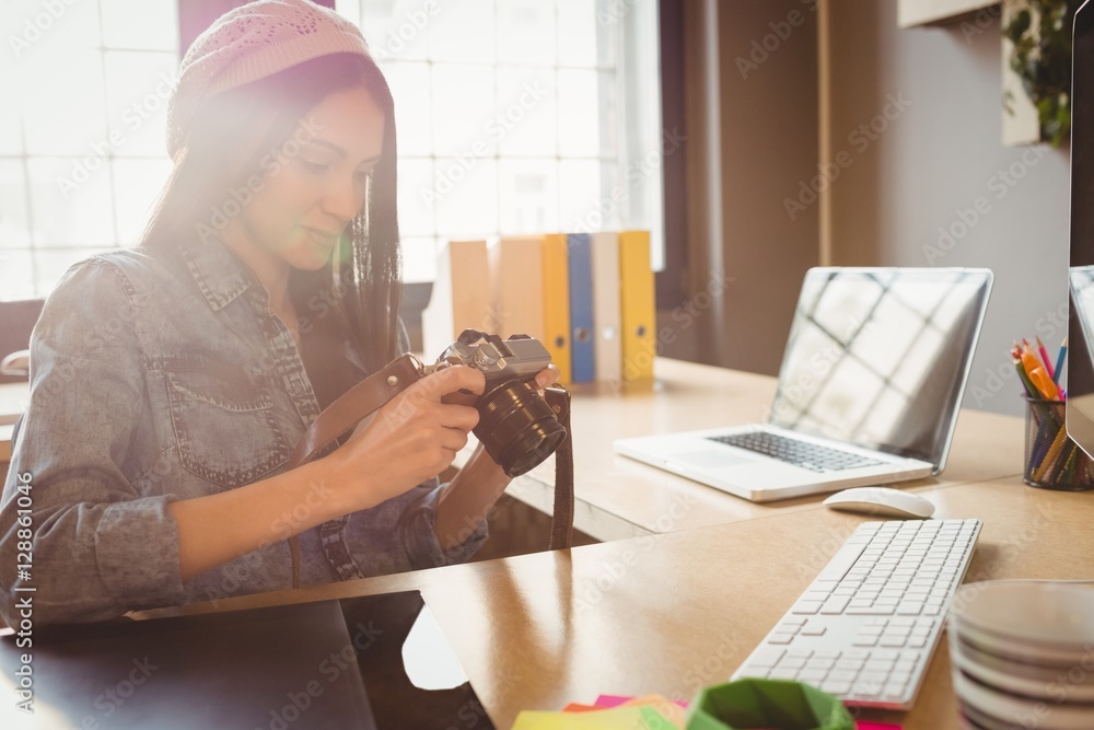 Fototapeta premium Graphic designer looking at pictures in digital camera