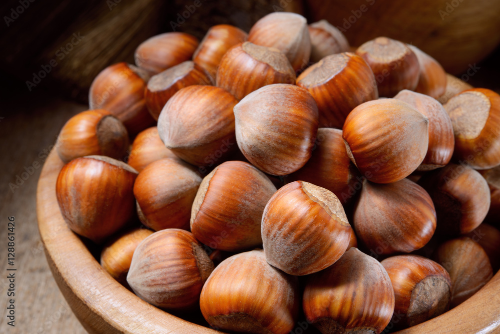 Hazelnut. Fresh organic filbert in wooden plate on dark backgrou Hazelnut. Fresh organic filbert in wooden plate on dark backgrou