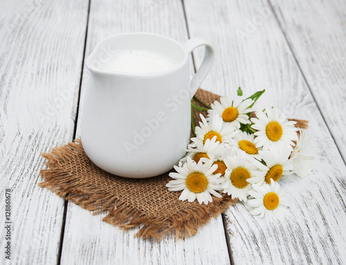 jug with milk  and chamomile flower