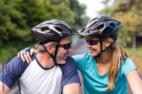 Athletic couple looking face to face while riding bicycle