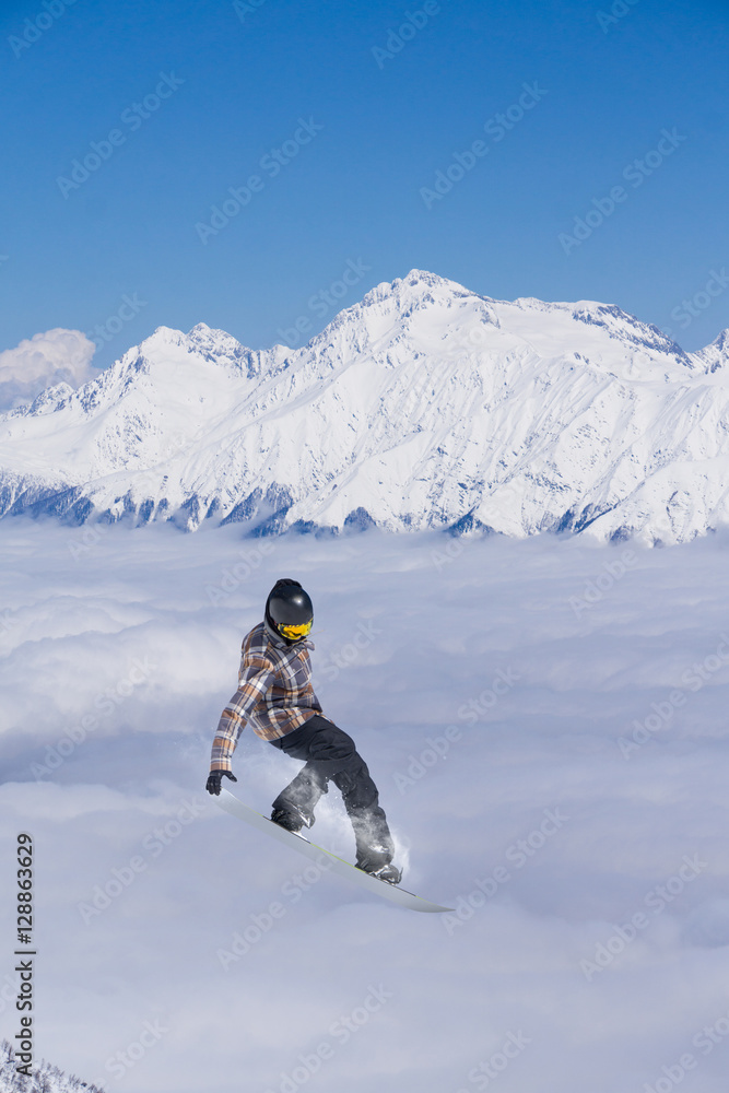 Rider jumping on mountains. Extreme snowboard freeride sport.