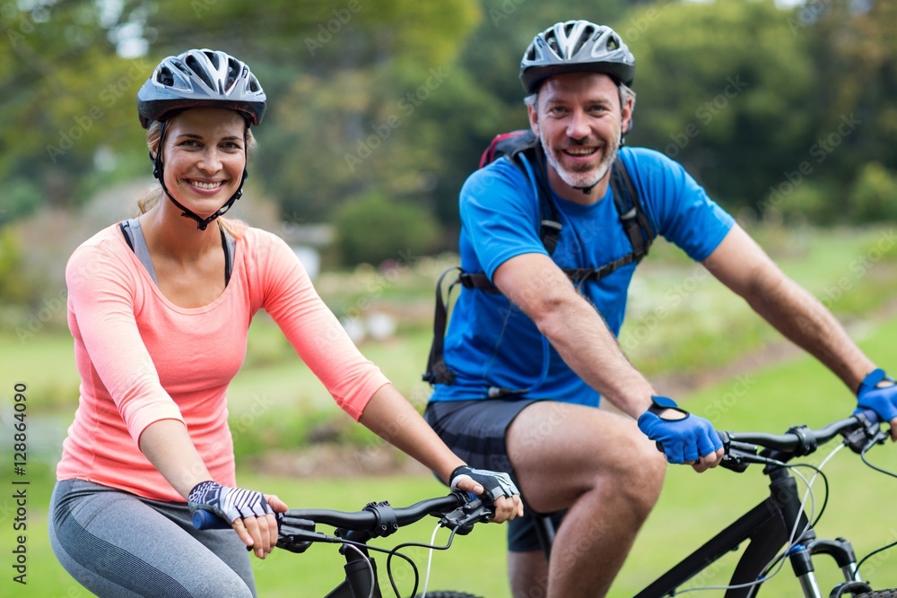 Naklejka premium Athletic couple cycling on the road