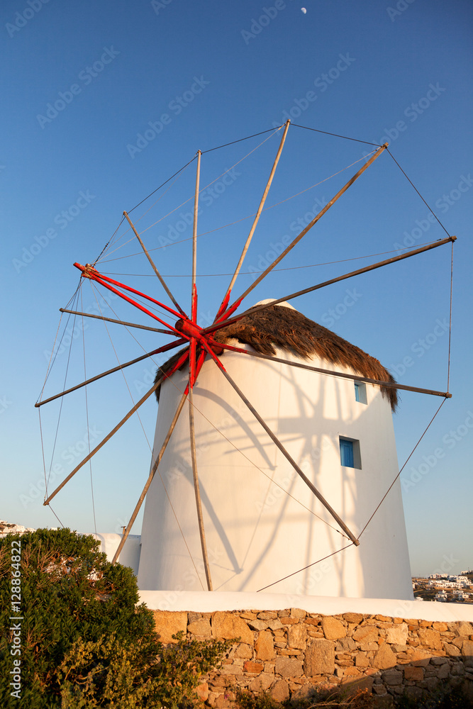 Windmill in front of a blue sky in Mykonos island, Greece at sun