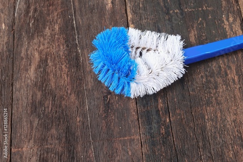 brush cleaning toilet on wooden floor background 