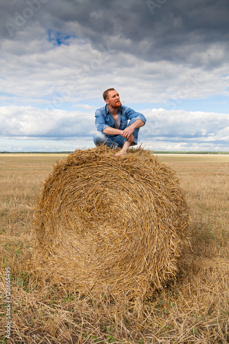 handsome man in jeans on hay