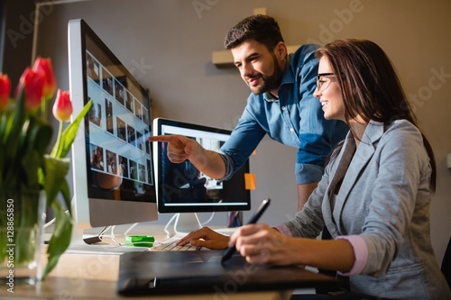 Graphic designer pointing at monitor