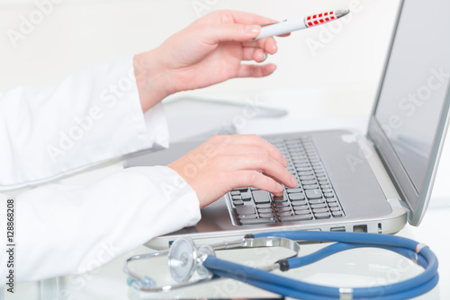 Medical doctor typing on laptop