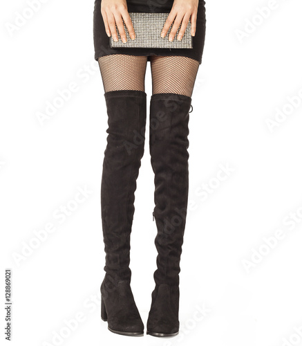 Woman legs in black suede boots on white background