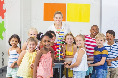 Portrait of kids and teacher standing in laboratory