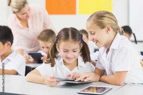 School kids using digital tablet in classroom