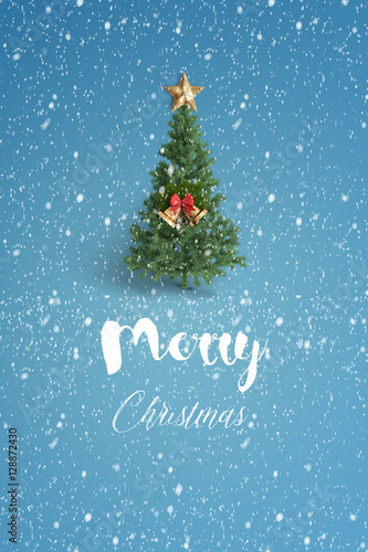 merry christmas and christmas tree with snow on color background