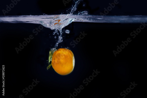 splash of tangerine in water. freshness concept