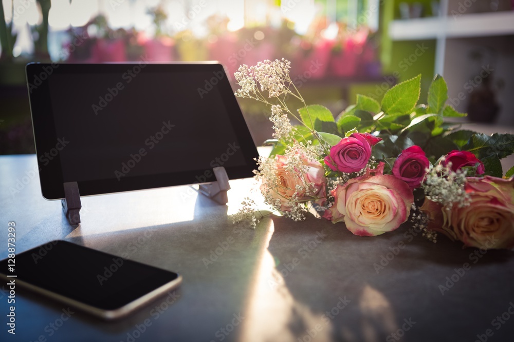 Obraz premium Flower bouquet with smartphone and digital tablet on the table