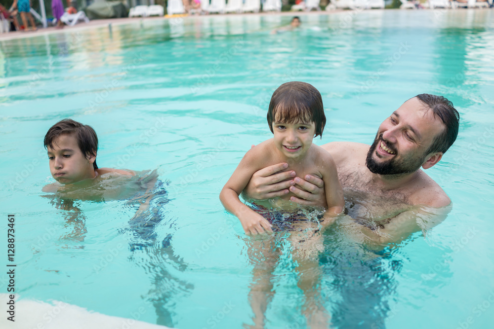 Young boy kid child splashing in swimming pool having fun leisur Young boy kid child splashing in swimming pool having fun leisur