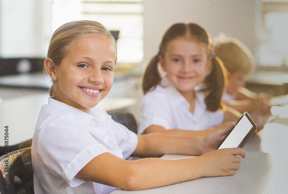 School girls using digital tablet in classroom School girls using digital tablet in classroom