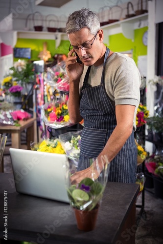 Male florist taking order on laptop