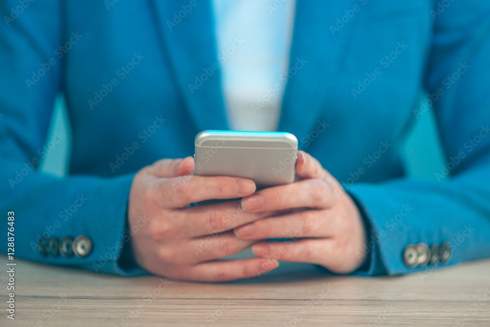 Businesswoman using smartphone, close up of hands