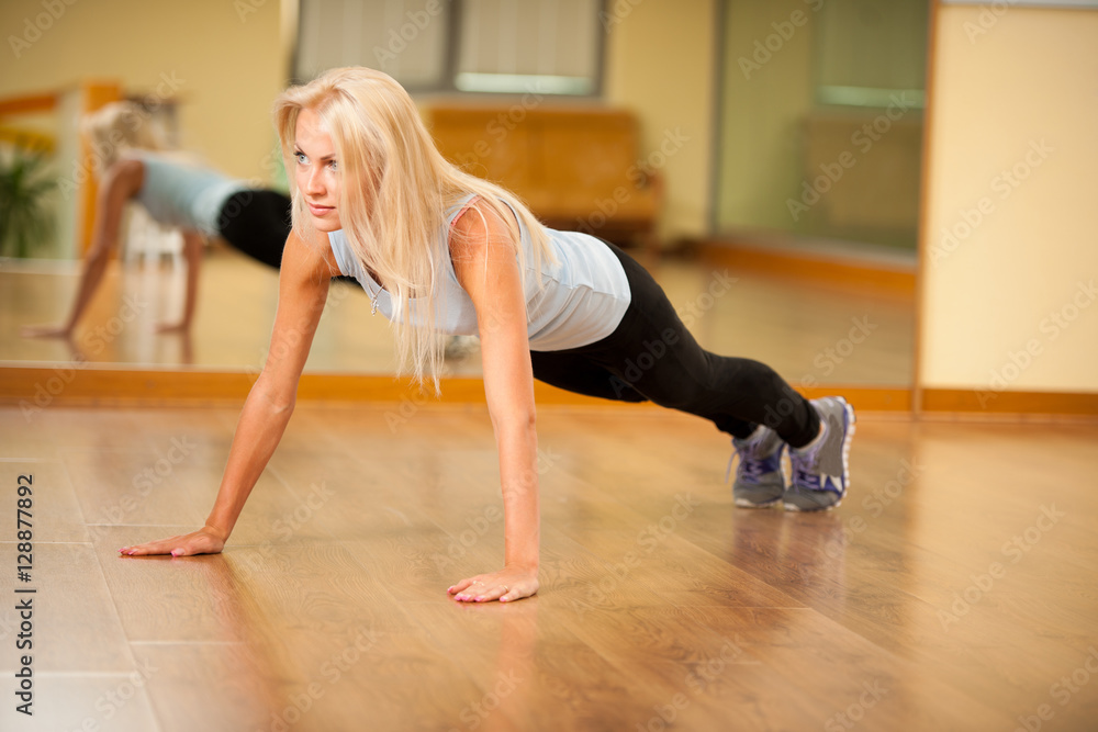 Fit woman works out in gym making push ups Fit woman works out in gym making push ups