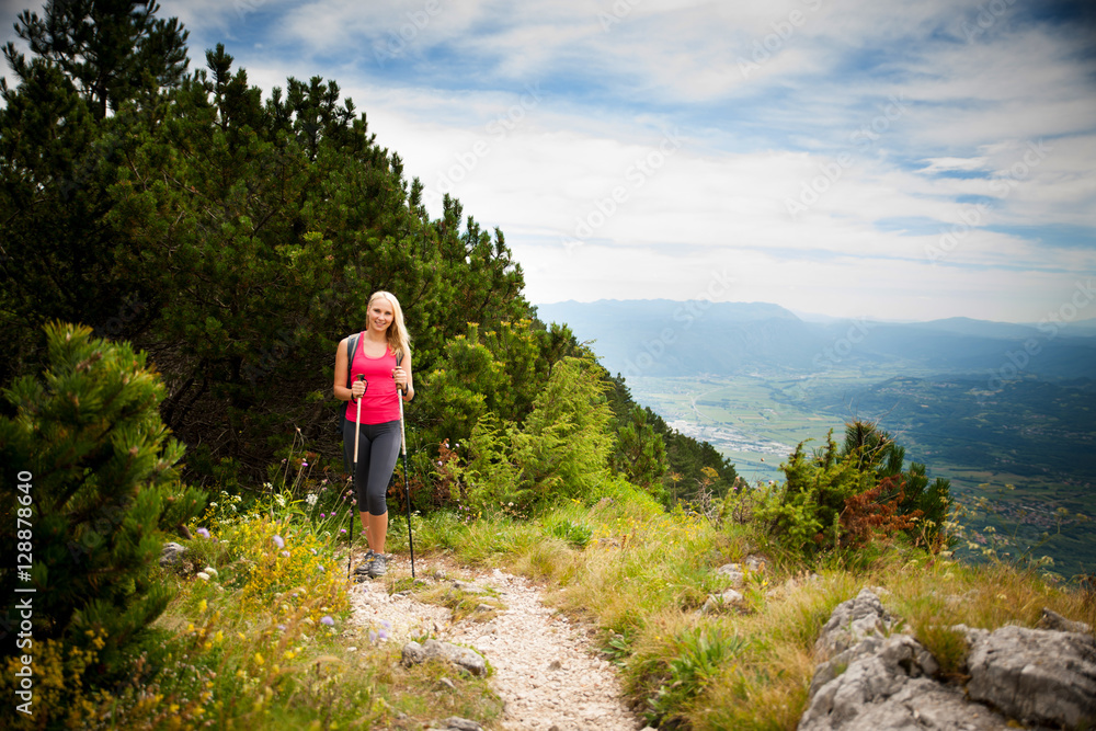 Trekking - woman hiking in mountains on a calm sumer day