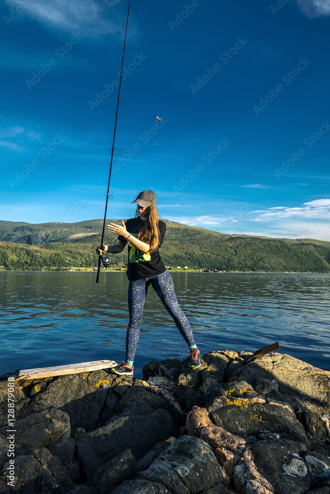 Young woman is fishing in Norway