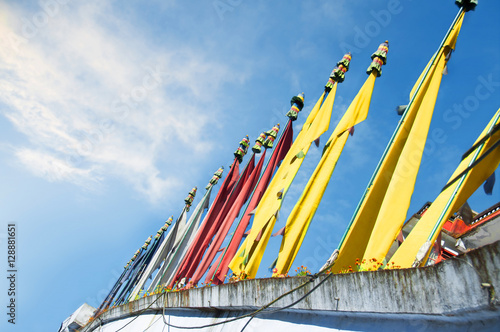 Tibetan prayer flags pyllons  at a blue sky photo