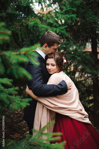 Bride and groom hugging in a forest in the autumn forest