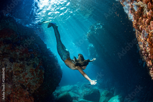 Mermaid swimming underwater in the deep blue sea Fototapet