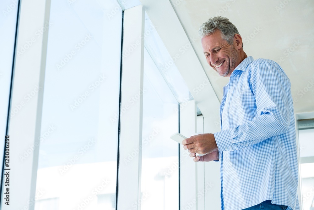 Low angle view of smiling man using phone Low angle view of smiling man using phone