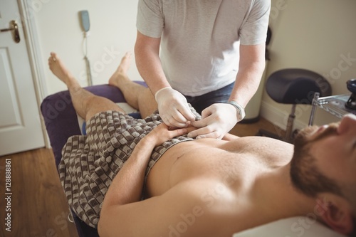 Physiotherapist performing dry needling on the hand of a patient