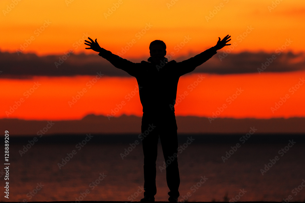 silhouette of a man on the beach, on a background of sea sunset